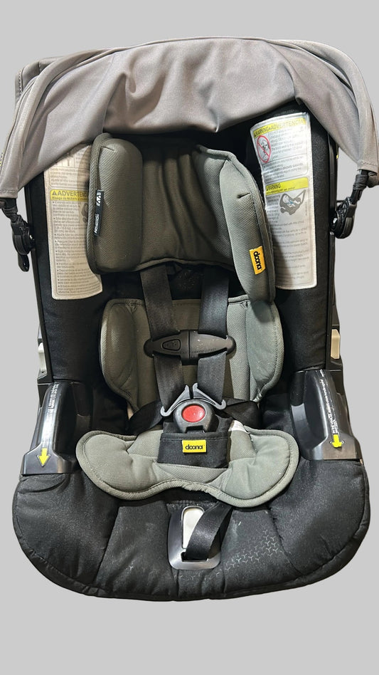 Baby car seat with a can of spray on a concrete floor