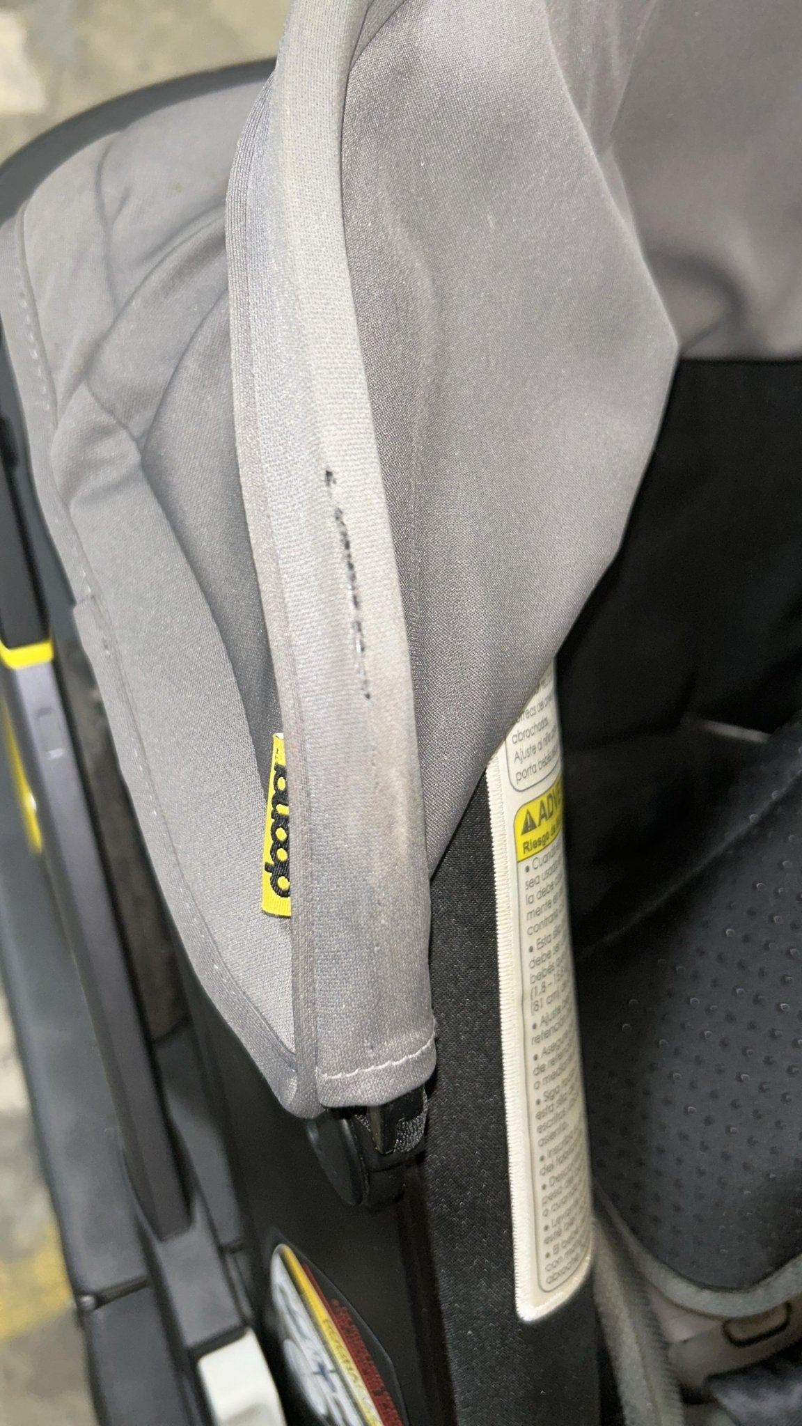Close-up of a gray car seat with a visible brand logo.